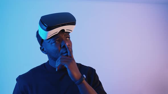 AfricanAmerican Guy with Virtual Reality Glasses on His Forehead  Thinking