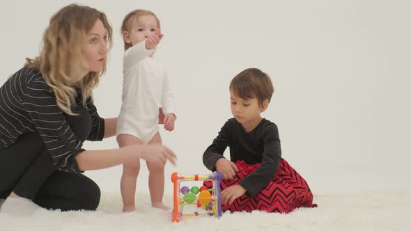 Two Little Girls Playing Toys in a White Room