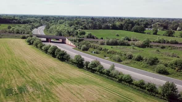 Drone flying over A34 trunk road which is intersected by a railway bridge crossing, showing transpor
