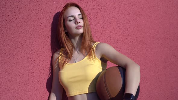 Young Attractive Woman with a Basketball Outdoors