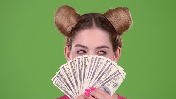 Girl Holds Paper Bills and Winks. Green Screen. Close Up. Slow Motion