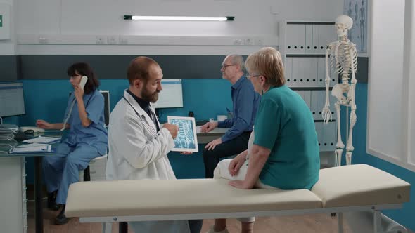 Medic and Old Woman Analyzing x Ray Scan Results on Tablet