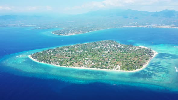 Beautiful fly over island view of a white sandy paradise beach and blue water background 