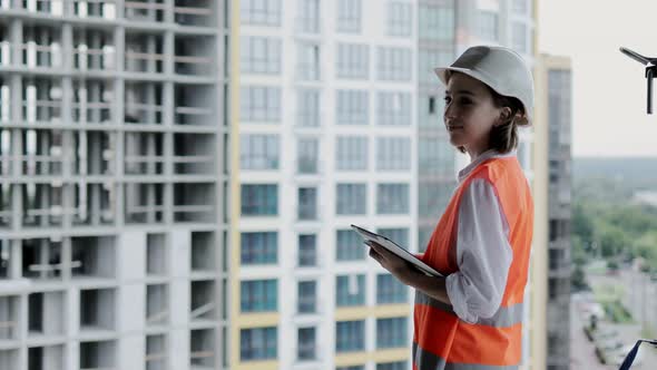 Architect working at Construction Site. A woman with a tablet at a construction site