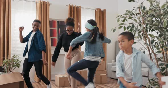 A Happy Family Dances in the Middle of the Living Room Young Parents and Their Children Celebrate