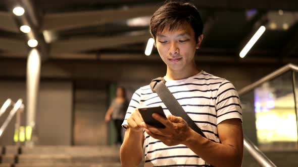Young man use of mobile phone in the city 