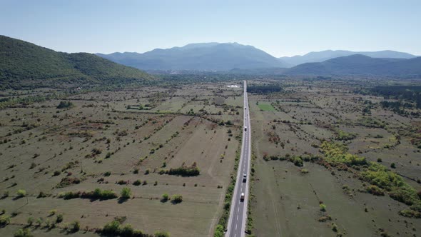 Empty Asphalt Road on the Plateau Between Green Fields Highland Way Aerial View