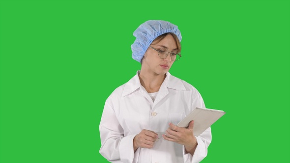 Young Positive Doctor Woman Taking Notes on Tablet