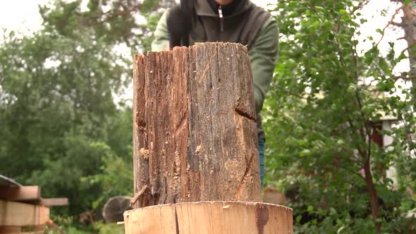 Splitting a wooden log in half with an axe. (slomo)