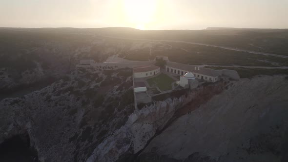 View of divine sunlight shining on rocky clifftop fort and chapel at Fortress of Beliche Sagres.