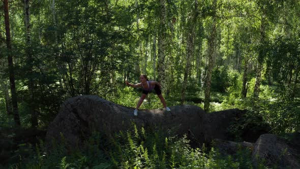 The Girl is Doing Fitness in the Forest