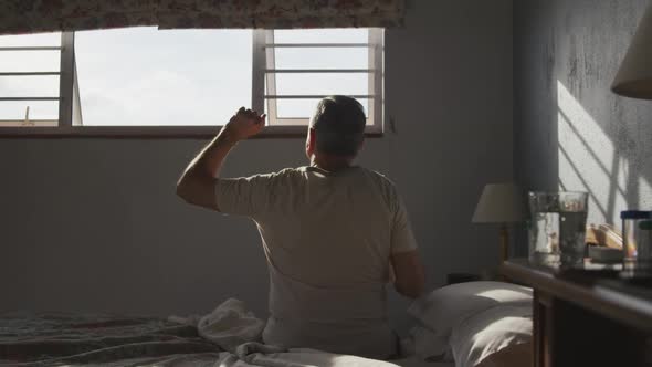 Senior man lying on bed at home