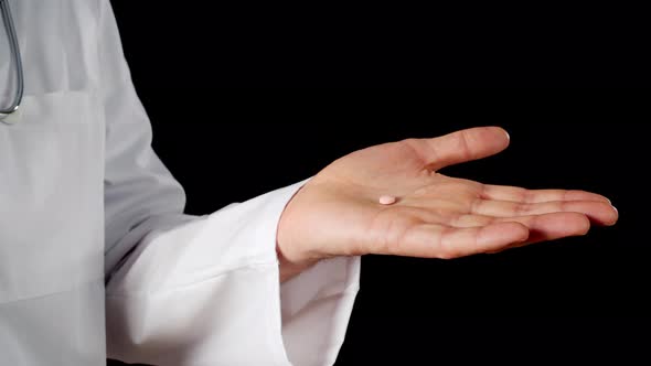 Close Up Pill on Male Hand Palm Isolated on Black Background. Doctor Hands Holding Tablet Drug