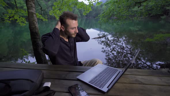 Businessman working with his laptop in nature.