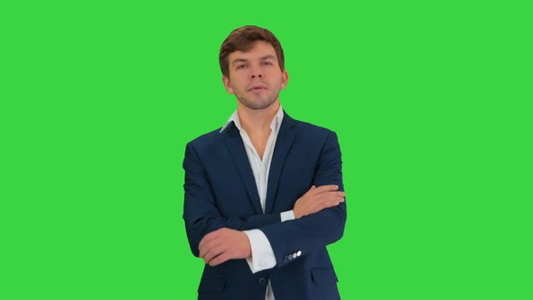 Confident Young Businessman Raising Finger and Folding Arms Looking at Camera on a Green Screen