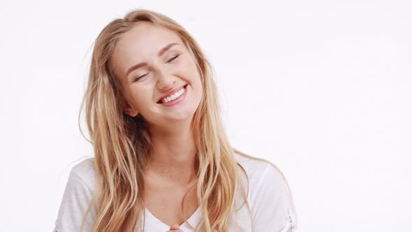 Young Beautiful Caucasian Blonde Girl Smiling Laughing on White Background in Slowmotion