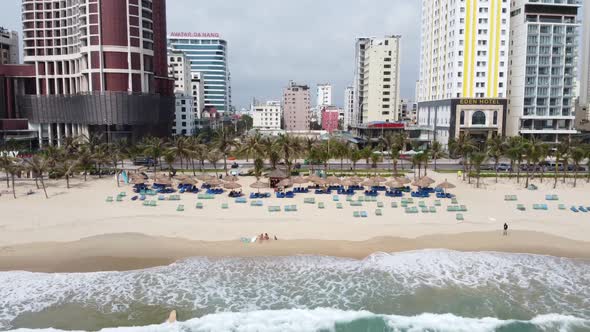 Cinematic Drone View of Coastal Beach in Da Nang Vietnam with View of the City Palm Trees Beach Hut