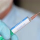 Close up of a researcher with face mask holding a syringe with coronavirus vaccine - VideoHive Item for Sale