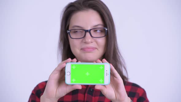 Face of Happy Young Beautiful Hipster Woman Thinking While Showing Phone