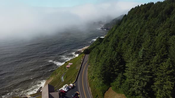 Clockwise drone shot of cars driving down the road overlooking a stunning ocean view on the Oregon C