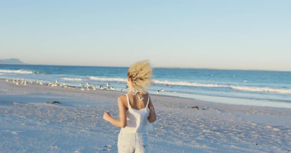 Young woman running on a beach 4k