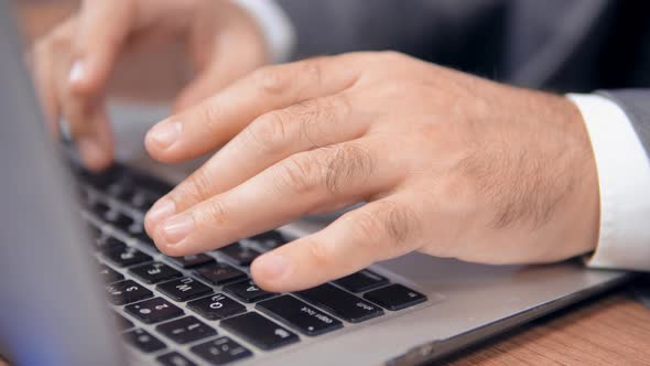 Male Hands Typing on Laptop Keyboard