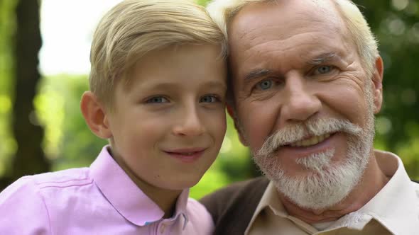 Boy and Old Man Posing for Camera, Smiling, Trusting Relations With Grandfather