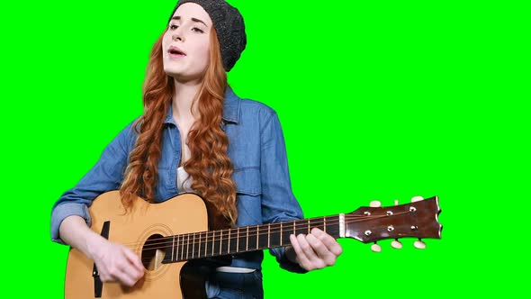 Female musician singing while playing guitar