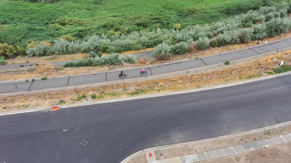 Aerial tilt down view of a couple on a cycling trip on a paved nature trail