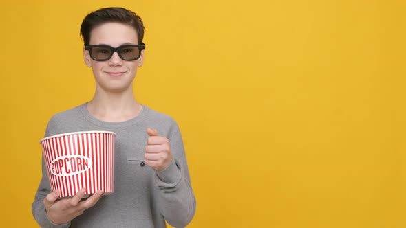 Teen Boy Gesturing ThumbsUp Wearing 3D Glasses Over Yellow Background