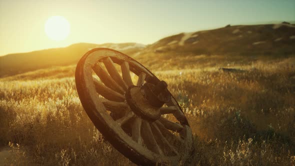 Old Wooden Wheel on the Hill at Sunset