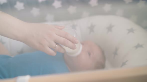 Mommy Feeds Little Son with Milk Mix in Comfortable Cocoon