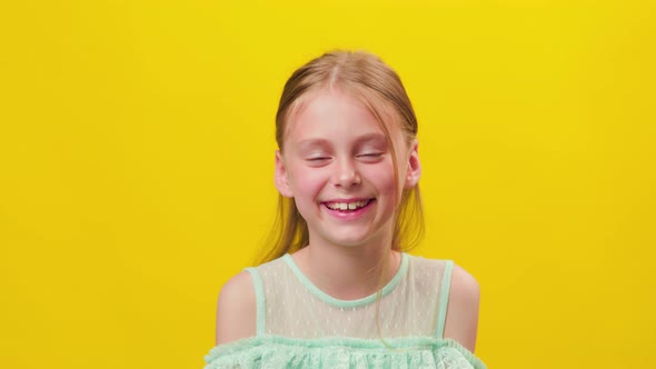 Little Girl Looking at Camera with a Strand of Hair on Her Face Smiling with Her Teeth