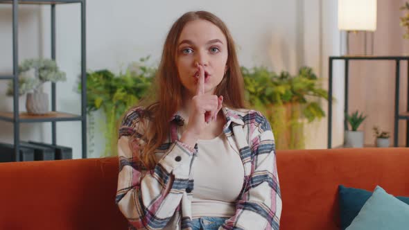 Young Woman Presses Index Finger to Lips Makes Silence Gesture Sign Do Not Tells Secret at Home