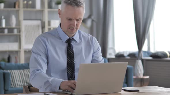 Gray Hair Businessman Working on Laptop