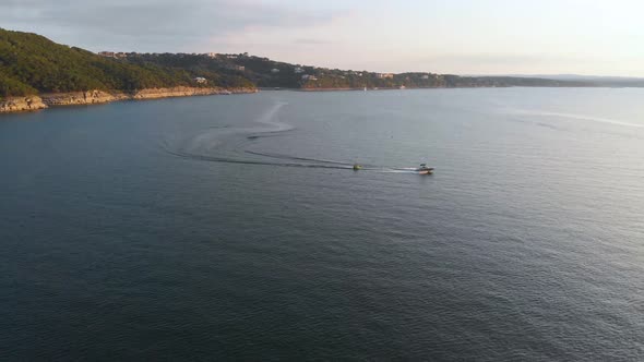 Drone shot of a boat pulling a tube on lake travis. Shot in Austin Texas on 9/10/20