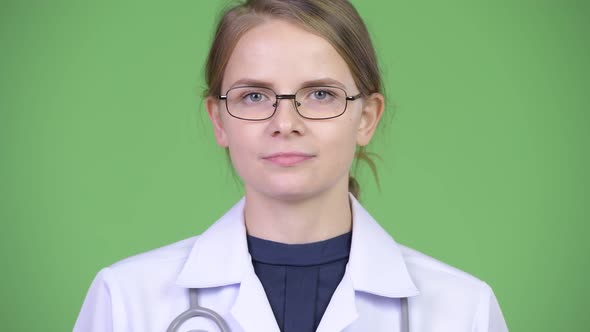 Young Happy Woman Doctor Smiling Against Green Background