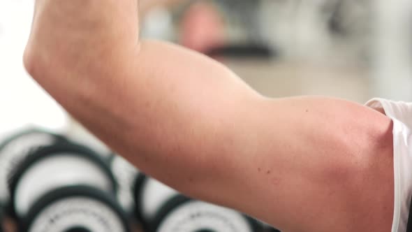 Close Up of a Muscular Young Man Lifting Weights.