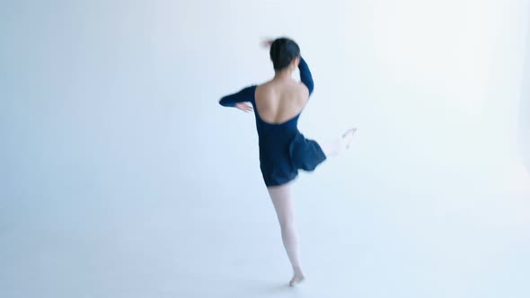 Girl Ballet Dancer in Blue Dress Spins in Dance Lifting Leg