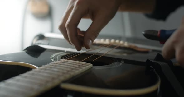 Guitar Tech Cuts the Strings on the Acoustic Guitar By Nippers in Slow Motion Restring the Guitar