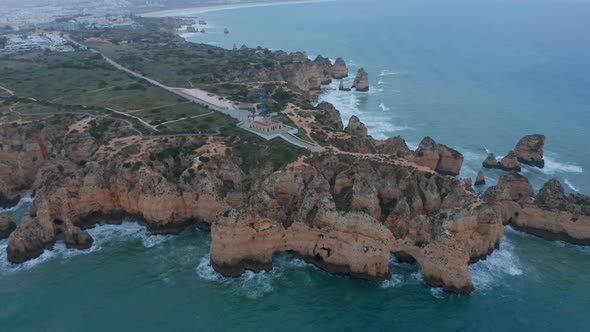 Spectacular Aerial Drone View of Lagos Portugal Coast Ocean with Lighthouse and Townscape on