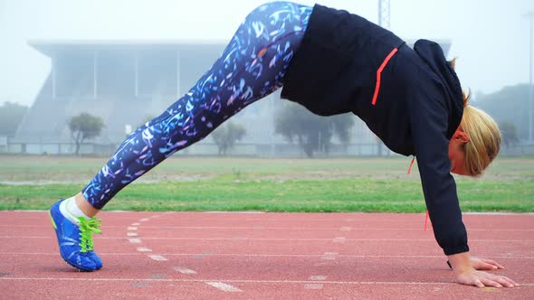 Female athlete exercising on a running track 4k