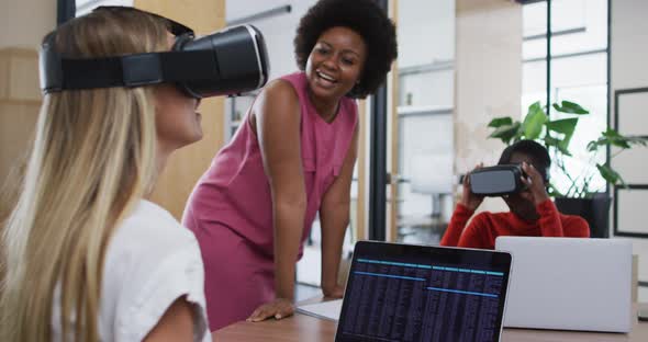 Diverse female office colleagues gesturing while wearing vr headset at office