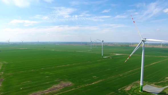 The wind power stations on the spring field, view from a drone