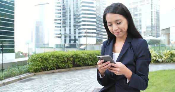 Businesswoman working on cellphone at city