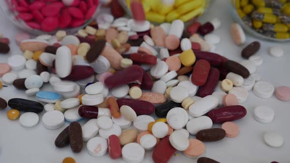 Macro shot of dropping tablets over table, View of white and brown tablets being dropped over table