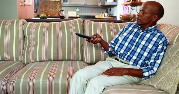 Senior man watching television in living room