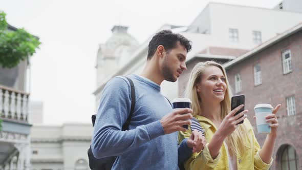 Side view of Caucasian couple on the go holding a takeaway coffee