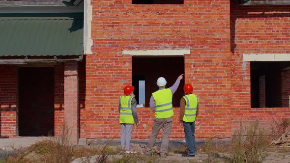 Architect with Senior Civil Engineers Discussing Project Work with Blueprint of Building House