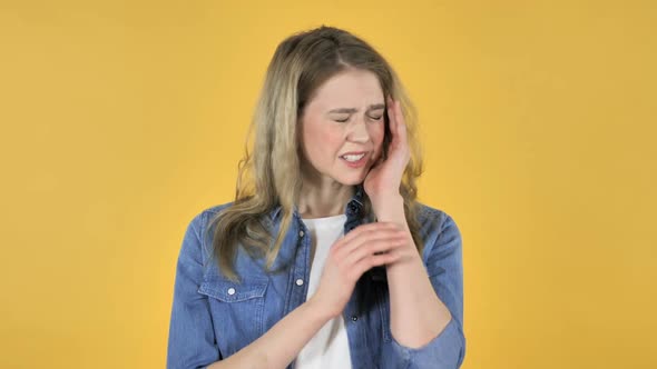 Young Pretty Girl with Headache on Yellow Background